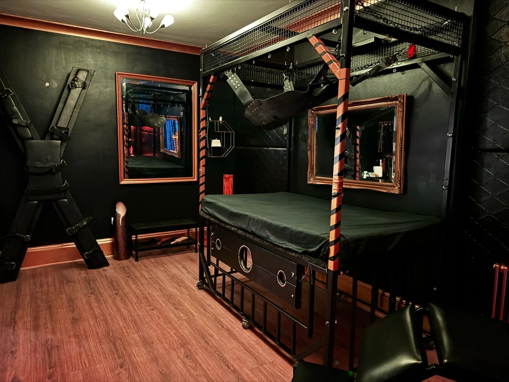 Private BDSM dungeon suite in London with a cage bed and bondage frame