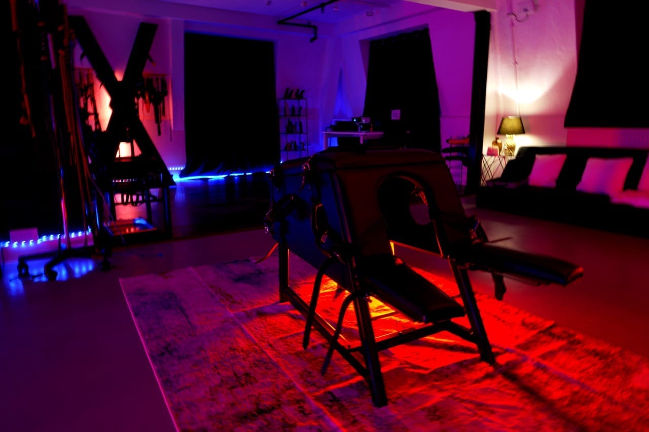 The open-plan dungeon of the BDSM penthouse at Tower Bridge in red and violet light