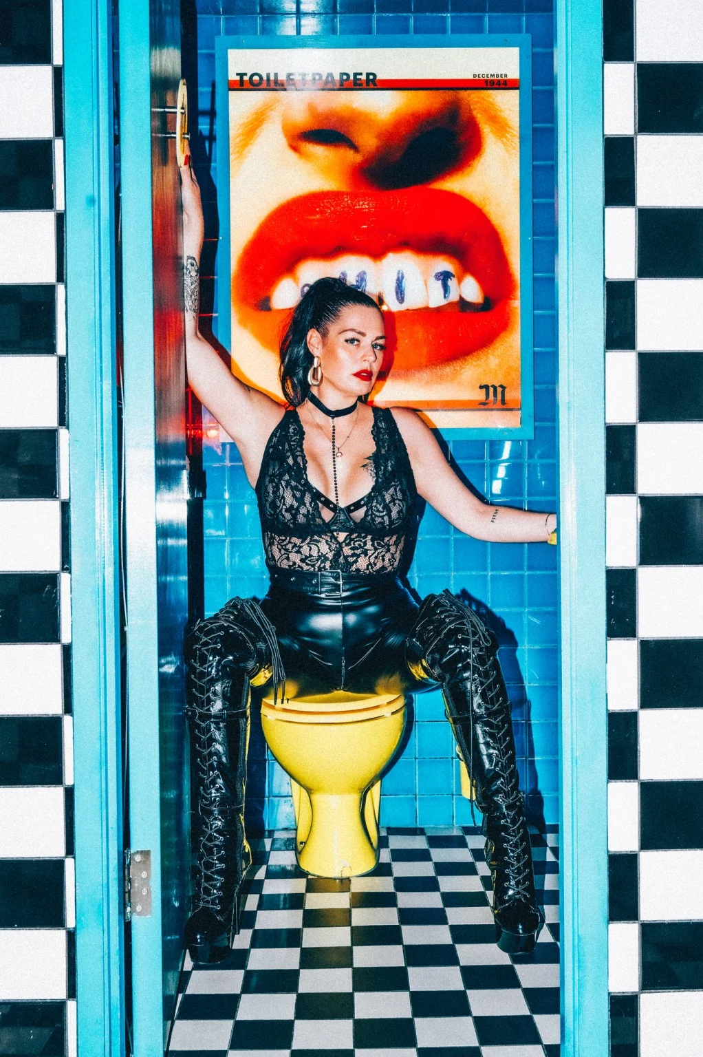 Mistress Charlotte O’Winter enthroned in a tiled washroom in latex and lace